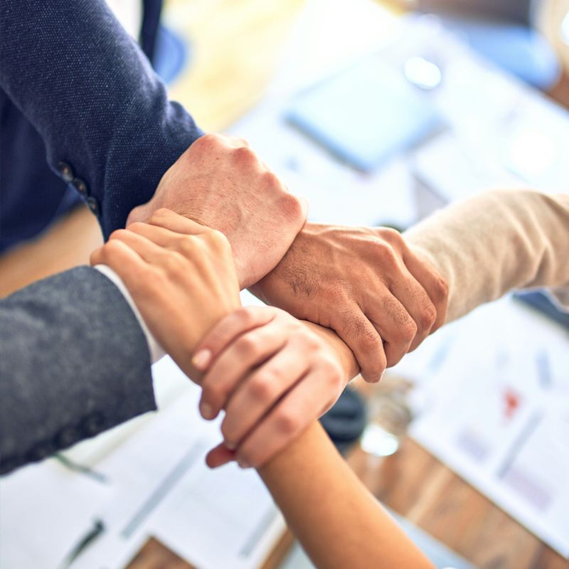 Equipo uniendo las manos en señal de colaboración